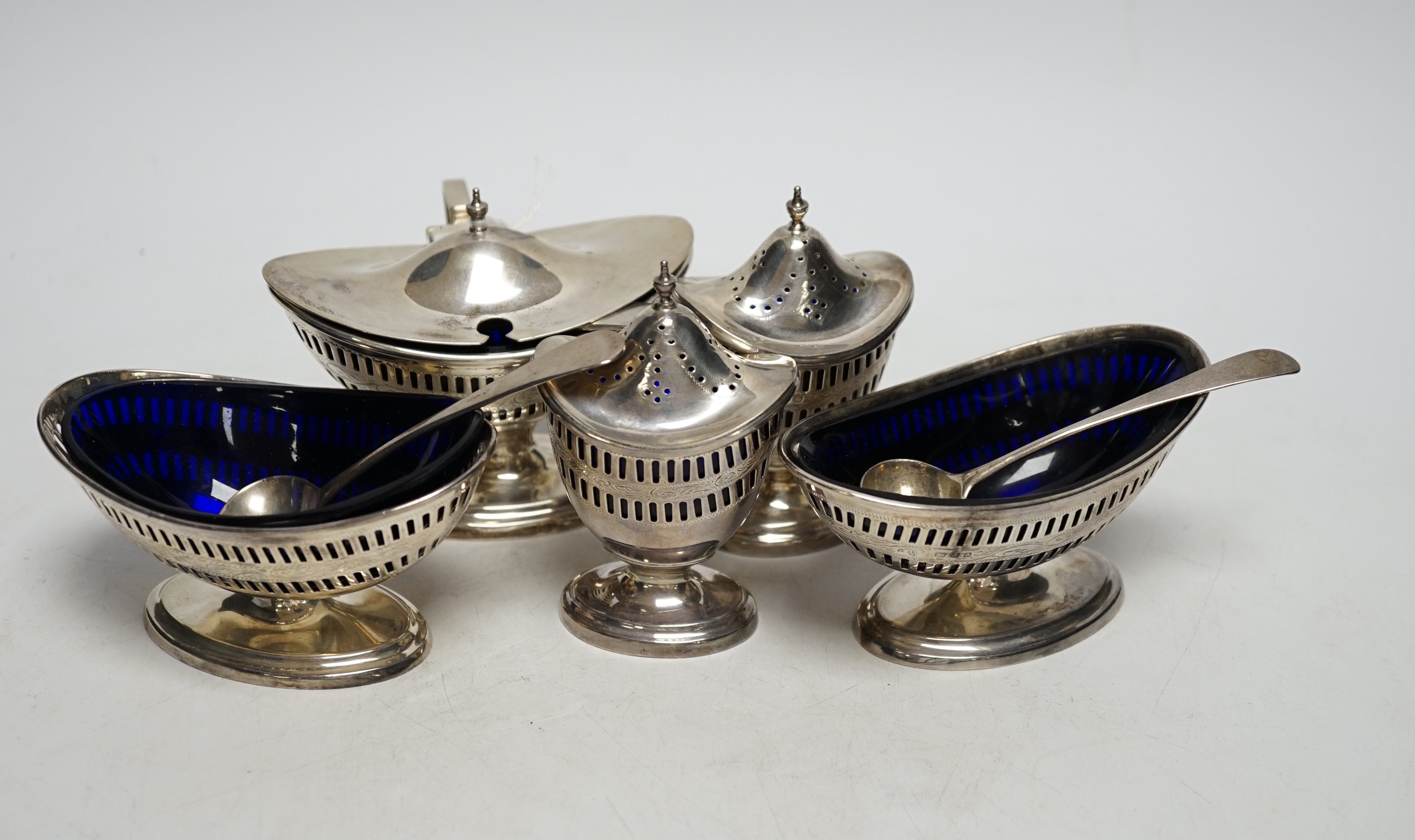 A 1930's George III style five piece silver cruet set, London, 1936/37, with three associated spoons, one silver plated.